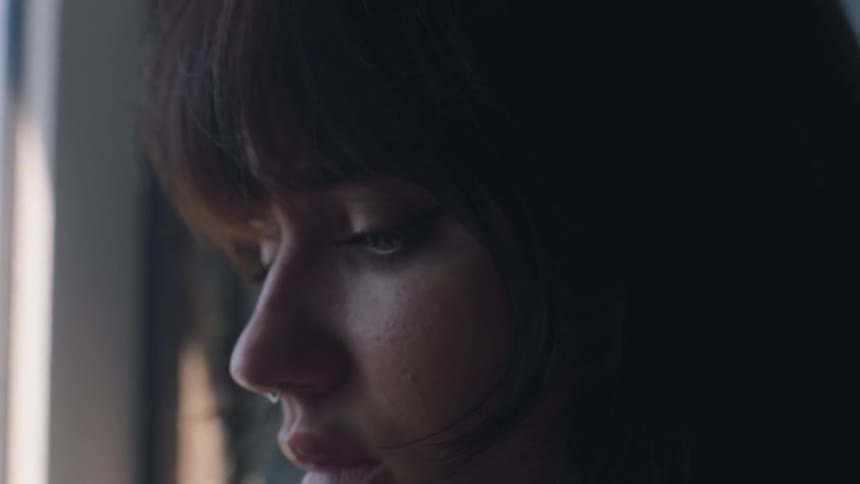A face of a young woman with a nose piercing