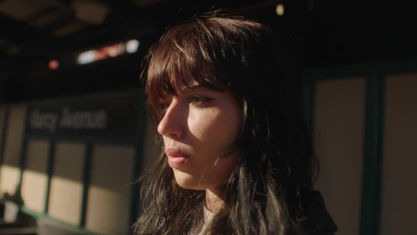 Portrait of a young woman looking up lowering her head and in a thoughtful pose