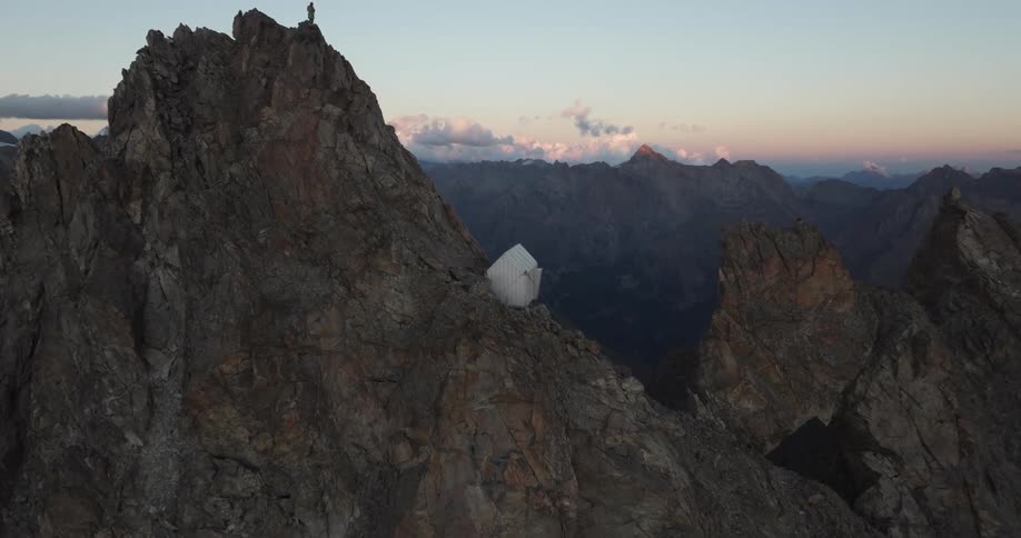 White house on the peak of jagged rocky mountain peak