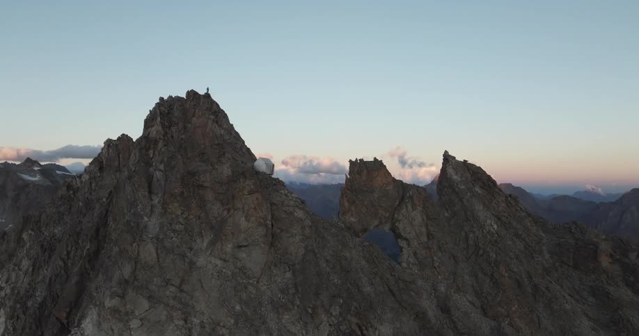 A single building is constructed high upon a mountain ridge