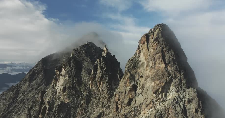 Aerial panorama of mountain peaks with a blue sky and clouds