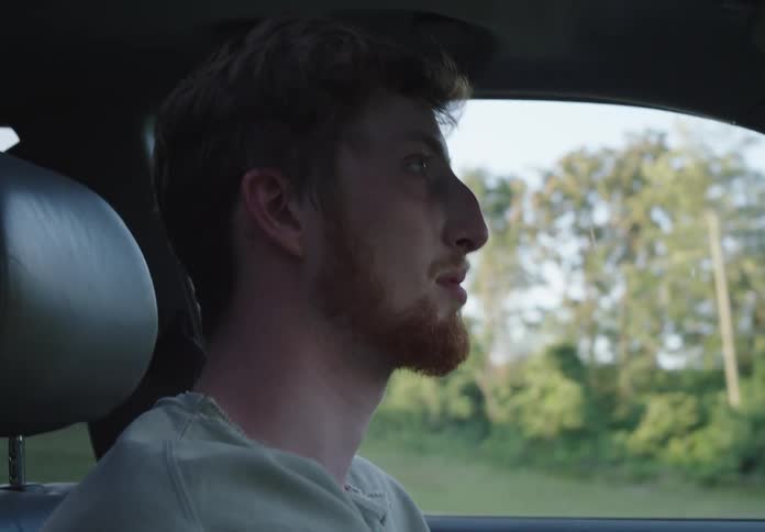 Red bearded man driving car in the countryside