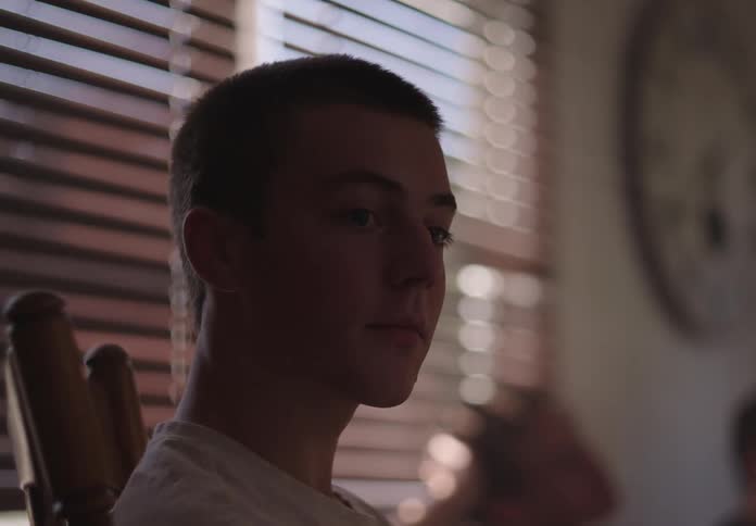 Portrait of a man sitting in a chair indoors looking thoughtful