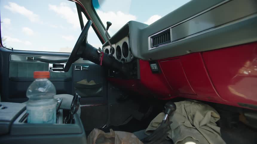 The front seats of a vintage vehicle are full of a lot of clutter