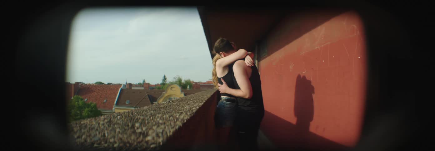 Young couple hug and kiss in a balcony