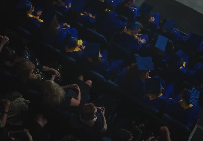 Several people in blue graduation clothes are sitting