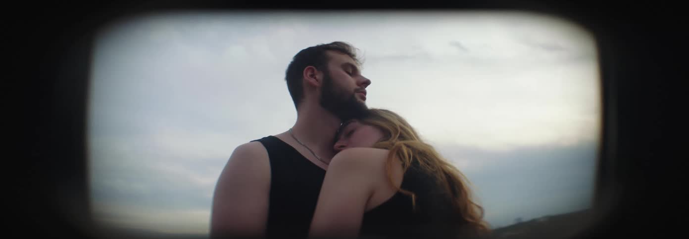 A couple embracing outdoors during sunset