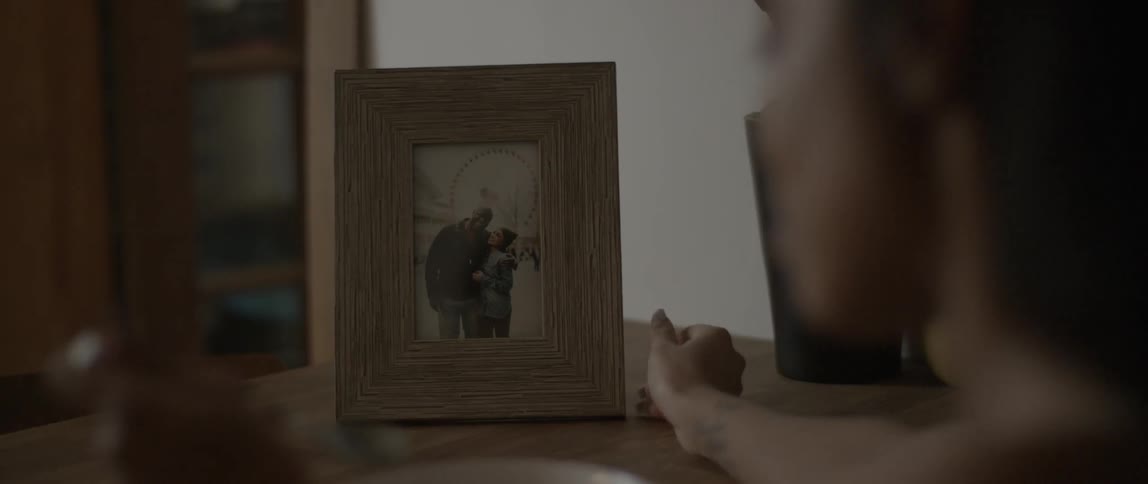 A woman adjusts a photograph and eats