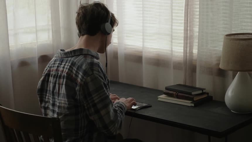 A man is using a tablet on a desk