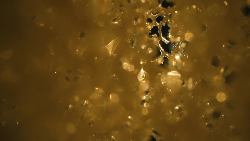 Extreme closeup of a dense golden abstract structure tearing apart