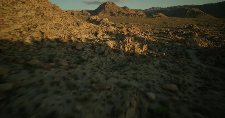 A rocky desert with empty dirt roads near the mountains