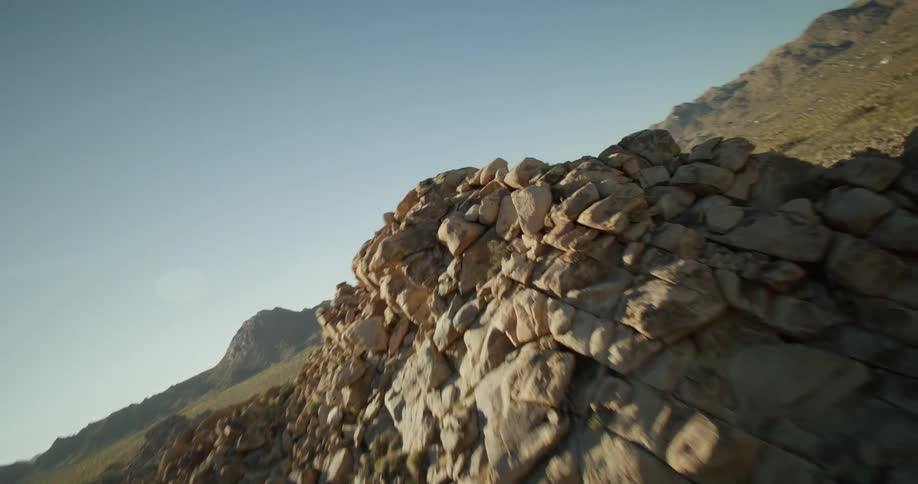 View of mountains with rock formations and sunlight reflection