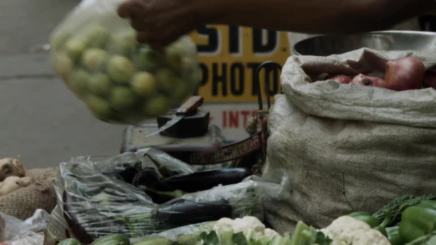 A man lifts a bag of fruit and places it down