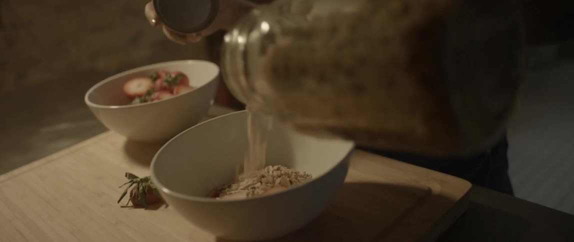 A woman is chewing as she prepares food