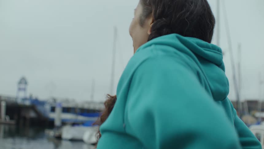 A woman is riding on a boat by the pier