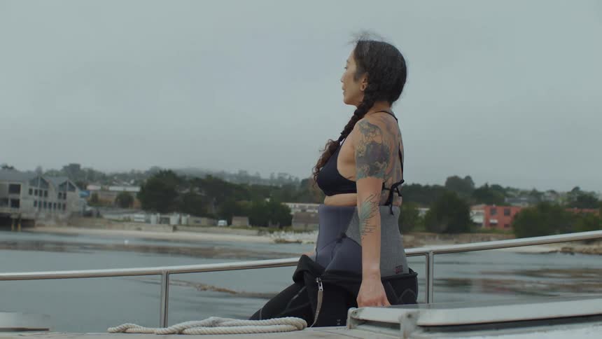 Woman stretches on a boat near the coast