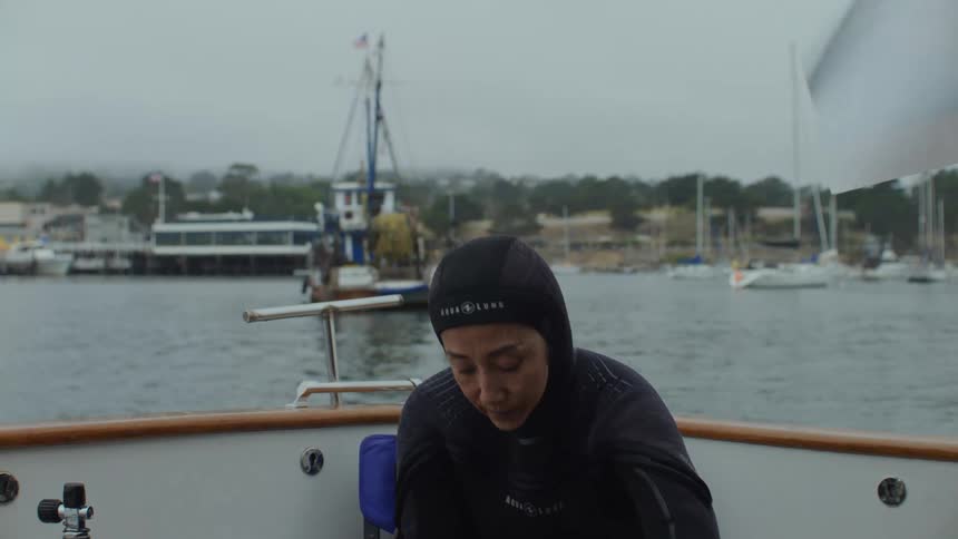 Woman getting ready for a dive off a boat