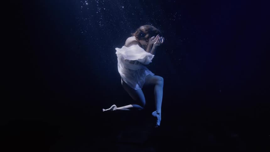 Artistic swimmer performs underwater in a pool