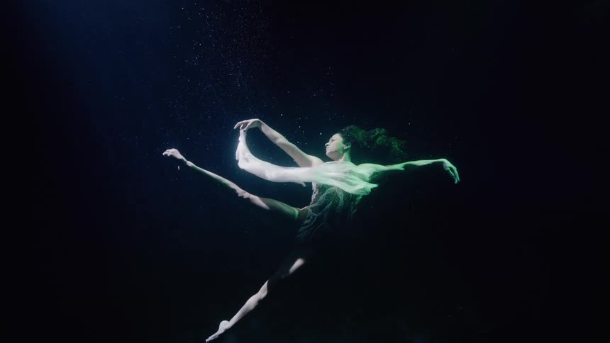 Dancer performing underwater with fabric
