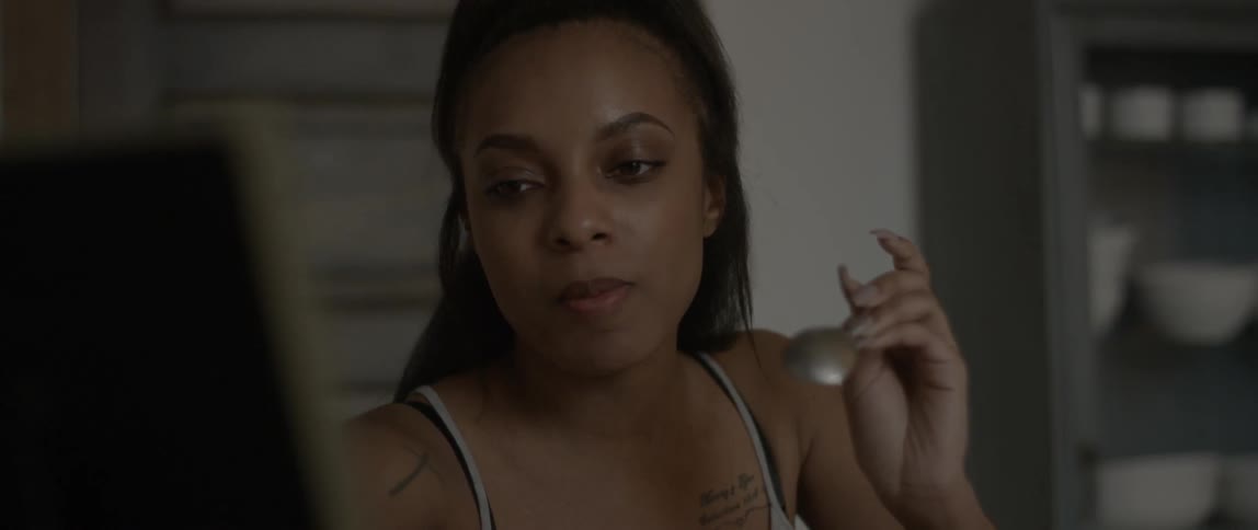 A woman is eating with a spoon