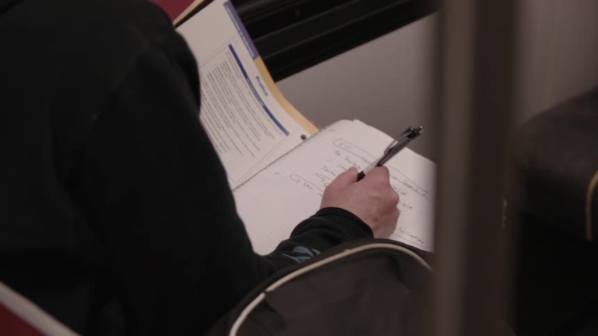 A person is writing in a book