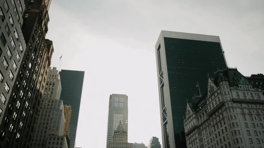 Tall buildings line a cloudy sky