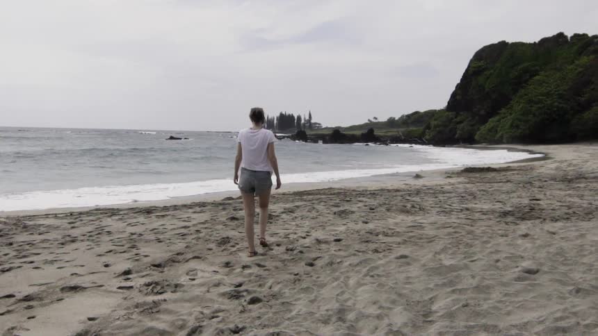 A woman is walking on the beach