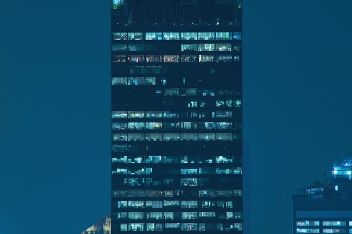 A skyscraper view in time lapse with office light turning off and on