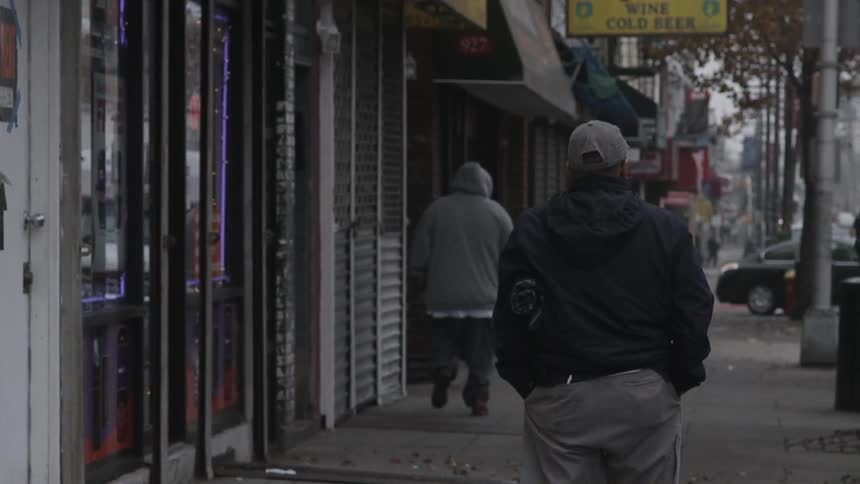 People walking down the sidewalk near storefronts