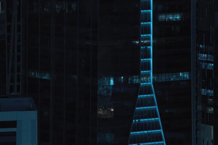 The exterior view captures condos in the city at night with lights turning off painting a vibrant and urban scene