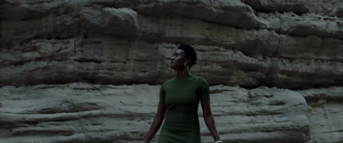 Woman walks backward looking lost near cliff