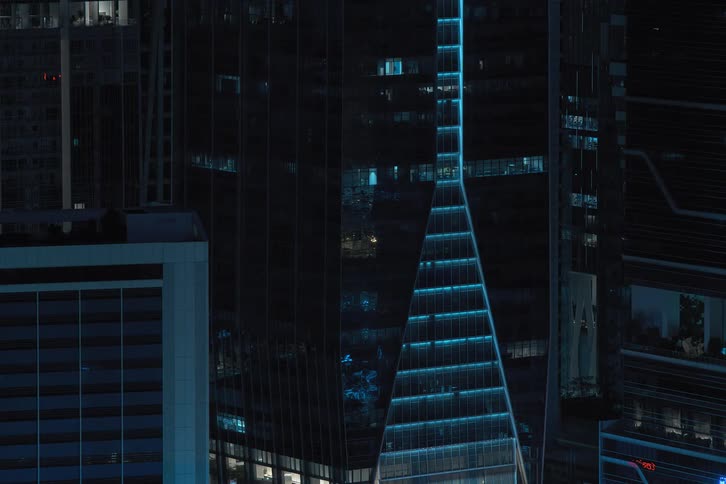 Exterior view of apartment buildings with flickering lights turning off at night