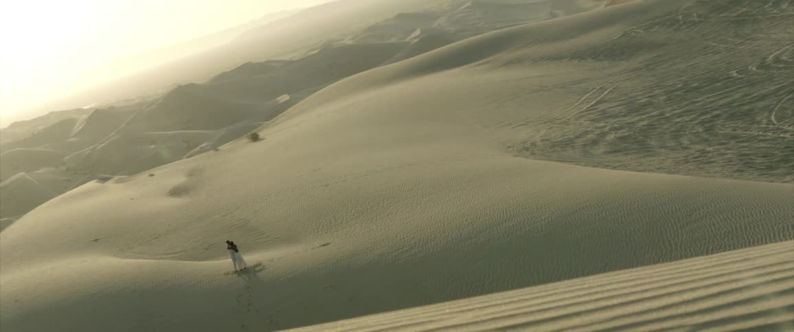 Person walking amidst the dunes in the desert