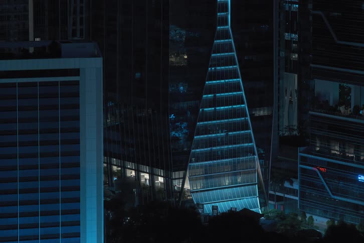 Mirrored buildings with city lights reflected in the glass turning off