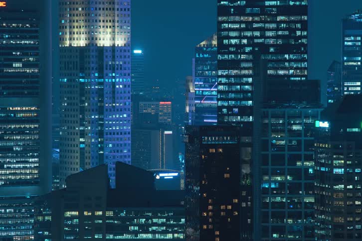 Aerial view of condos and office buildings with flickering lights in the city at night