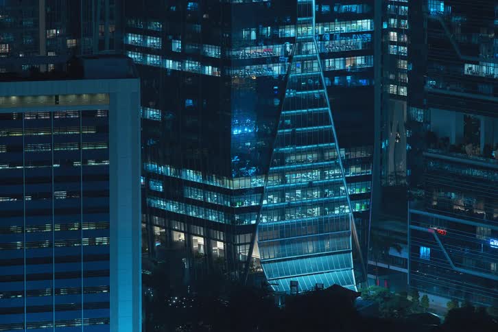 The exterior view captures condos in the city at night with lights flickering painting a vibrant and urban scene