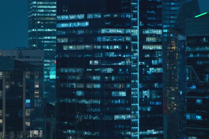 View of buildings in the midst of a metropolis at night in time lapse with lights blinking and flashing