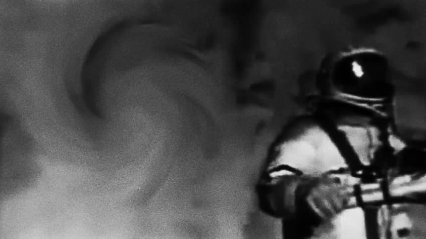 Astronaut wearing space suit floats through gas filled area