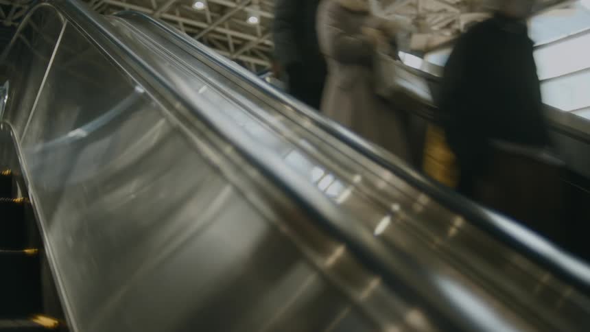 A group of people go down an escalator