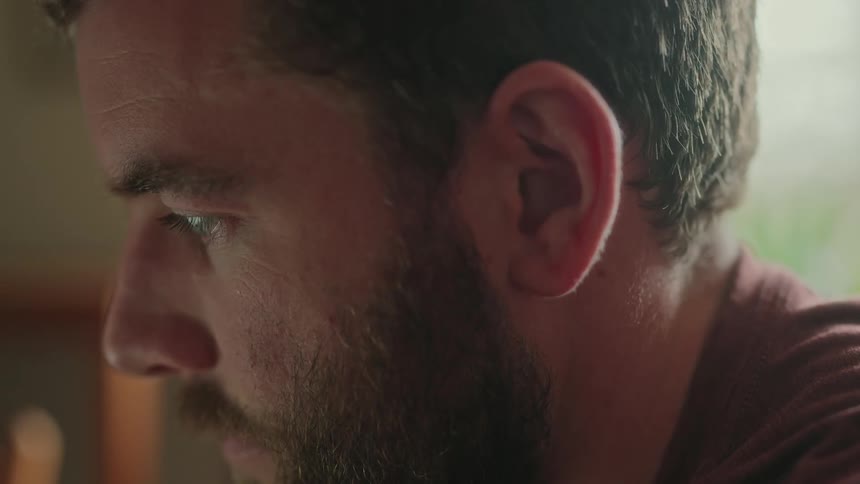 A mans close up face is looking at something in front of him
