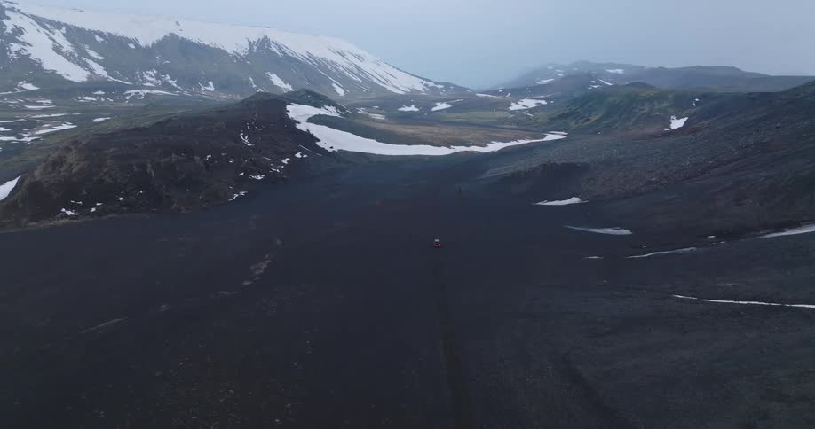 Skyline of a car driving in nature with plains and mountains with snow at the peak