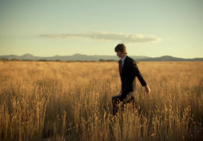 A lost man walking through a pasture in a rural area