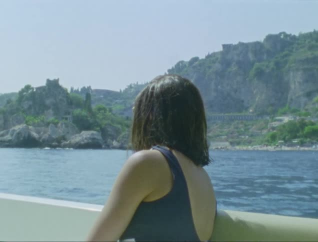 Woman sitting on a boat with her back turned enjoying the scenery
