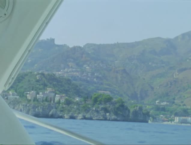 A boat is traveling past the coast
