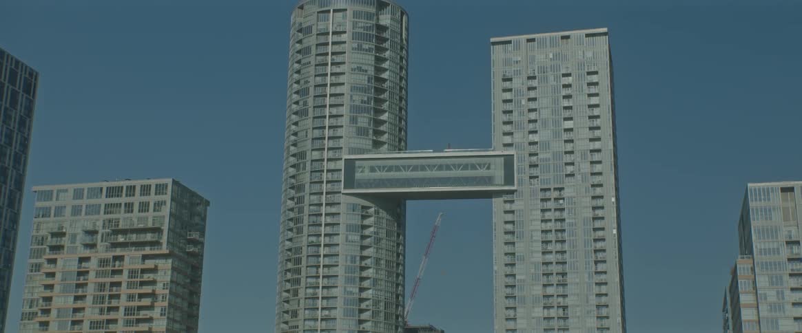 View of two connected towers in skyscrapers in a metropolis under a blue sky