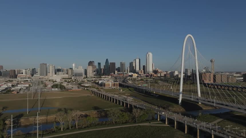 Aerial view of a cablestayed bridge and city skyline with the bridges white tower standing out against the backdrop of skyscrapers and other buildings