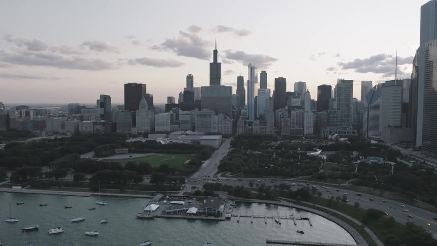 Aerial of a body of water and a highway with skyscrapers in the background