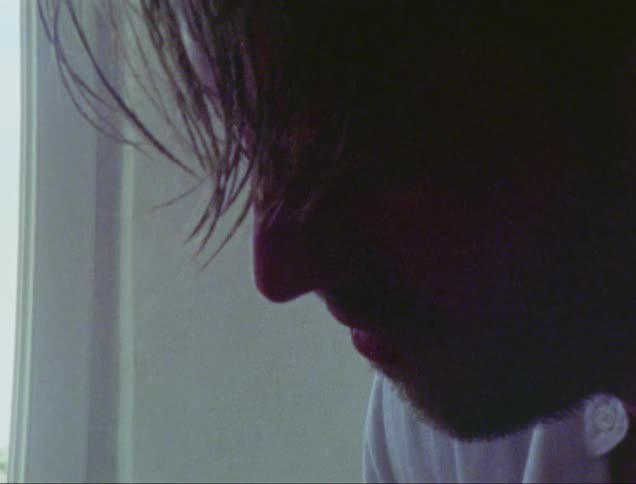 A man with a beard is looking at the ground