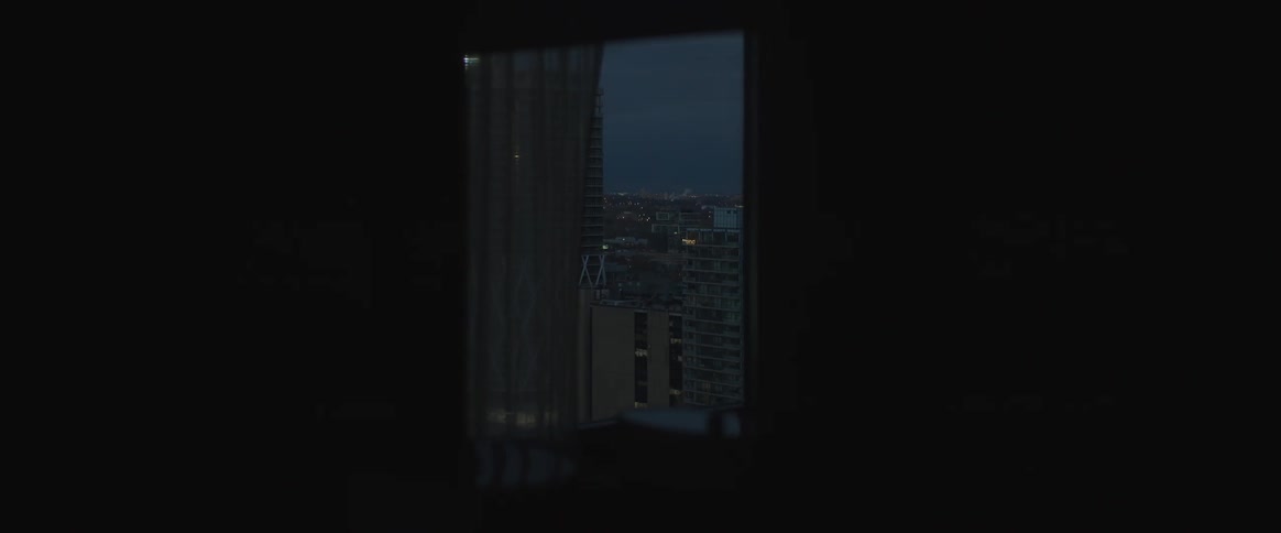 Outside the pitch black room is a city