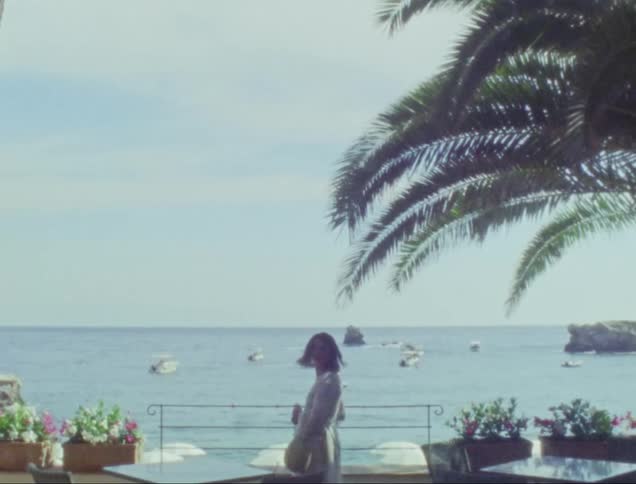 Woman enjoying the sea view on an outdoor balcony